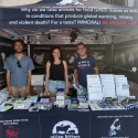 Three volunteers smiling at the camera from the Vegan Justice booth
